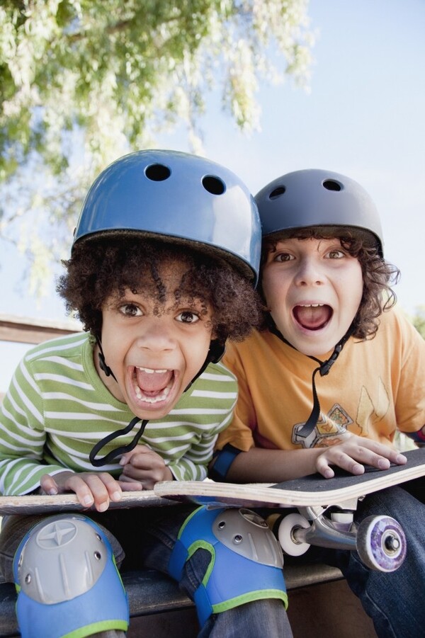 2 kids holding a skateboard yelling with cheer